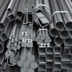 Different metal rolled products. Stainless steel profiles and tubes. in warehouse background.